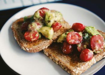 bread with tomato and green vegetable on white ceramic plate