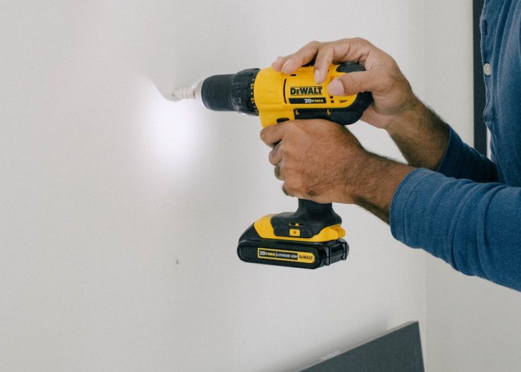 person holding yellow and black cordless hand drill