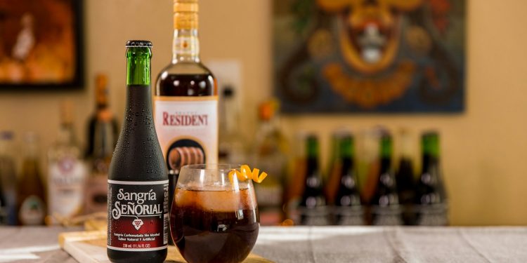 black glass bottle beside clear drinking glass