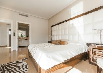 brown wooden bed frame with white cover beside brown wooden nightstand