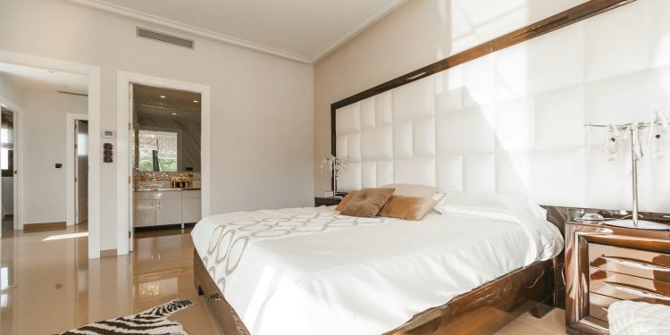 brown wooden bed frame with white cover beside brown wooden nightstand