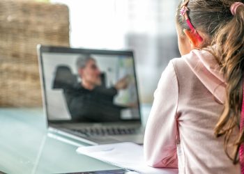 woman in pink long sleeve shirt sitting in front of macbook pro