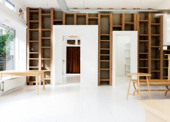 two beige wooden tables in white room
