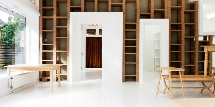 two beige wooden tables in white room