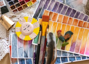 brown wooden handled brush beside white round plastic