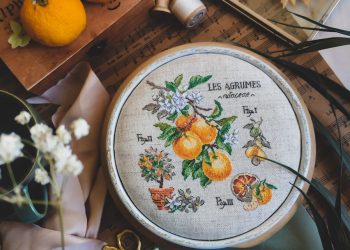 a close up of a cross stitch on a table