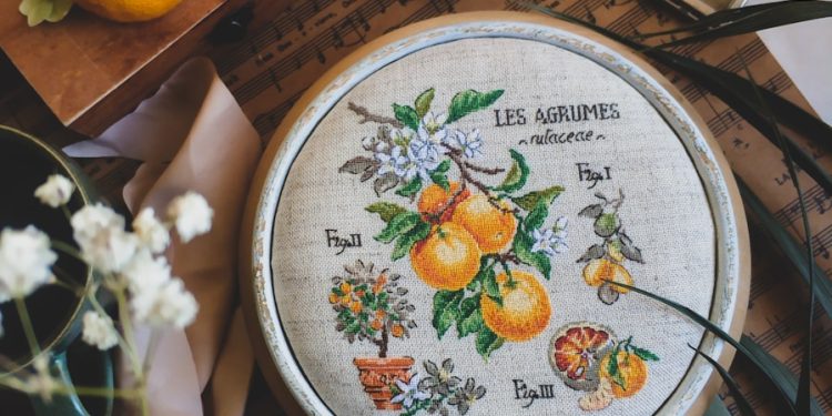 a close up of a cross stitch on a table
