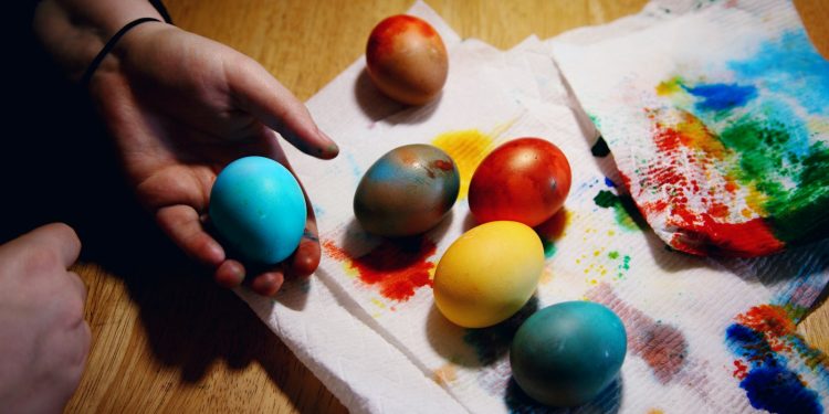 person holding red yellow and blue egg