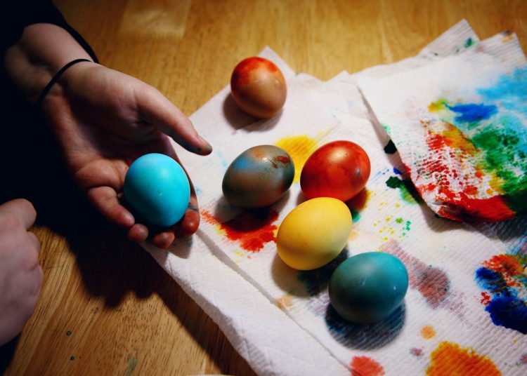 person holding red yellow and blue egg