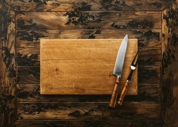 a knife and a board on a wooden surface