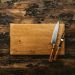 a knife and a board on a wooden surface