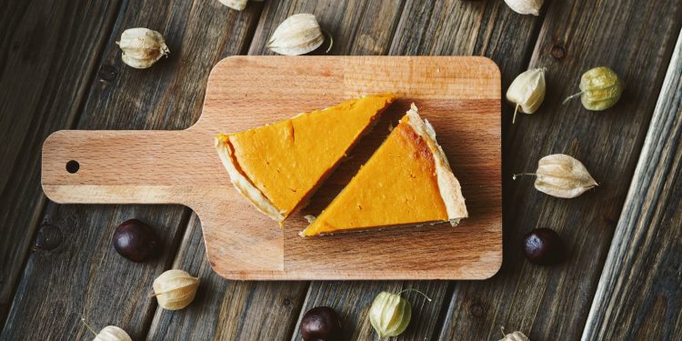 two sliced pies on brown wooden chopping board