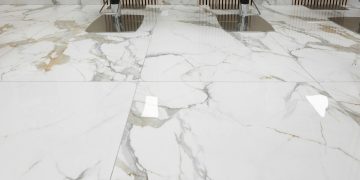 three chairs sitting on a marble floor in a room